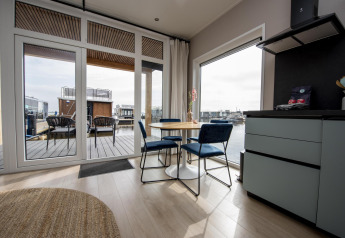 Zona pranzo moderna nella houseboat 'Riggelbrug' presso Welcome In - Friesland, Paesi Bassi, vista sull'acqua.