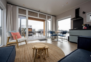 Gemütlicher Innenraum einer Hausboot-Lodge mit modernem Design und Terrasse mit Wasserblick in Friesland.