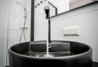 Moderno lavandino nero con acqua corrente nel bagno di Houseboat 'Riggelbrug', Welcome In - Friesland, Paesi Bassi.