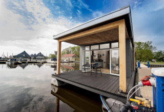 Moderno houseboat 'Riggelbrug' en Welcome In - Friesland, Países Bajos, flotando junto al puerto deportivo.
