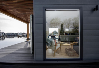 Vista della houseboat Riggelbrug a Welcome In - Friesland, Paesi Bassi, con interni moderni e terrazza sul lungomare.