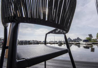 Vista attraverso una sedia al porto della Houseboat 'Riggelbrug', Welcome In - Friesland, Paesi Bassi.