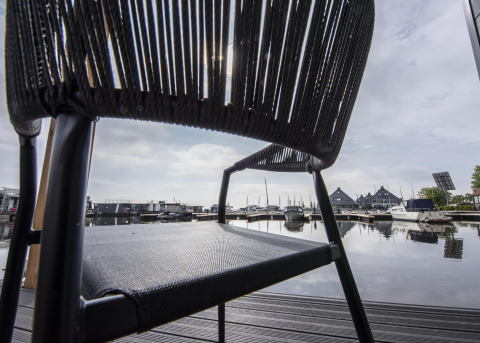 Vista a través de una silla en el puerto de Houseboat 'Riggelbrug', Welcome In - Friesland, Países Bajos.