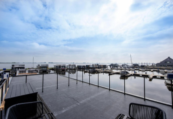 Vista dalla houseboat 'Riggelbrug' al Welcome In - Friesland, Paesi Bassi, con il porticciolo e il cielo.