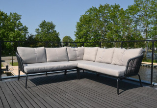 Ecksofa auf Terrasse mit Blick auf Wasser und Bäume, Houseboat 'Riggelbrug' bei Welcome In, Friesland, Niederlande.