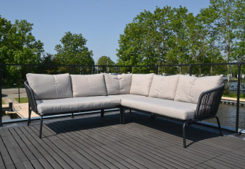 Outdoor corner sofa on a deck overlooking water and trees at Houseboat 'Riggelbrug', Friesland, Netherlands.