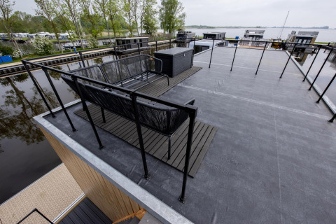 Dachterrasse des Hausboots 'Riggelbrug' bei Welcome In - Friesland, mit Blick auf Wasser und Boote.