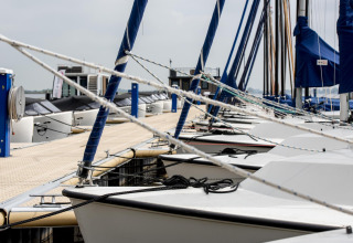 Boten aangemeerd aan het ponton van houseboat 'Riggelbrug' bij Welcome In - Friesland, Nederland.