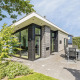 Moderne Natuurlodge aan Recreatiepark het Esmeer in Nederland met grote ramen en gezellige terrasruimte.