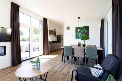 Sala de estar y comedor moderna y luminosa en Natuurlodge de Recreatiepark het Esmeer, Países Bajos.