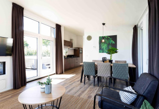 Lichte, moderne leef- en eetruimte in de Natuurlodge van Recreatiepark het Esmeer, Nederland.