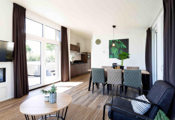 Lichte, moderne leef- en eetruimte in de Natuurlodge van Recreatiepark het Esmeer, Nederland.