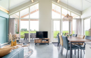 Helles, modernes Wohnzimmer in der Anker-Lodge bei Tusken de Marren, Niederlande, mit Panoramafenstern.