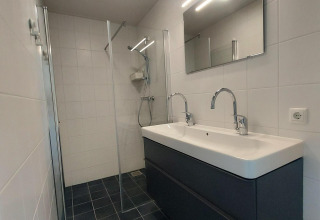 Bagno moderno con doppio lavabo e doccia in vetro presso la lodge Anker, Tusken de Marren, Paesi Bassi.