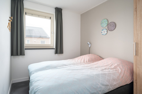 Chambre lumineuse et moderne avec deux lits simples à la lodge Anker, Tusken de Marren, Pays-Bas.