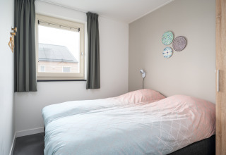 Lichte en moderne slaapkamer met twee aparte bedden in Anker lodge, Tusken de Marren, Nederland.