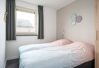 Lichte en moderne slaapkamer met twee aparte bedden in Anker lodge, Tusken de Marren, Nederland.