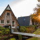 Tiny house Wellness Lodge à Hof van Salland aux Pays-Bas, entourée de verdure au coucher du soleil.