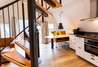 Moderna tiny house Wellness Lodge a Hof van Salland, Paesi Bassi, con scala a chiocciola e cucina.