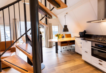 Moderne tiny house Wellness Lodge bij Hof van Salland, Nederland, met draaitrap en knusse keuken.