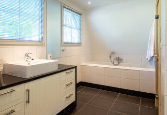 Bagno moderno nella Wellness Lodge a Hof van Salland, Paesi Bassi, con vasca e lavandino ampio.