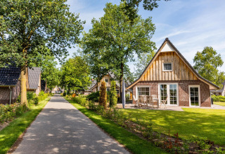 Acogedora cabaña Wellness Lodge en Hof van Salland, Países Bajos, rodeada de árboles y senderos tranquilos.