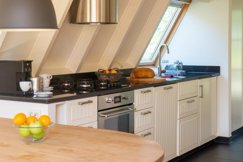 Moderne køkken i Wellness Lodge, Hof van Salland, med friske frugter, kaffe og friskbagt brød.