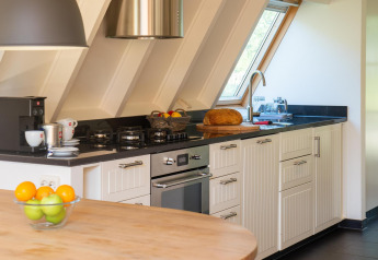 Moderne keuken in Wellness Lodge, Hof van Salland, Nederland, met vers fruit, brood en koffie.