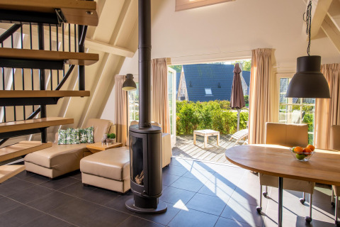 Tiny house Wellness Lodge a Hof van Salland nei Paesi Bassi con soggiorno aperto su terrazza e giardino.