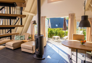 Gezellige Wellness Lodge tiny house in Hof van Salland, Nederland, met open woonkamer en toegang tot terras.