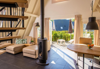 Tiny house Wellness Lodge a Hof van Salland nei Paesi Bassi con soggiorno aperto su terrazza e giardino.