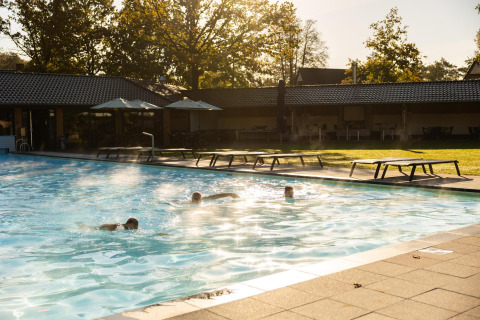 Piscina esterna al Wellness Lodge, Hof van Salland nei Paesi Bassi, con ospiti che nuotano al mattino.