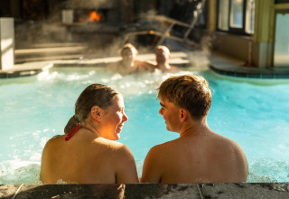 Due persone si rilassano nella piscina della Wellness Lodge al Hof van Salland nei Paesi Bassi.