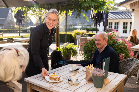 Serveuse apportant gâteau et café en terrasse à la Wellness Lodge, Hof van Salland, Pays-Bas.