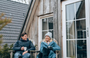 Twee mensen ontspannen bij de Wellness Lodge tiny house van Hof van Salland in Nederland op een frisse dag.