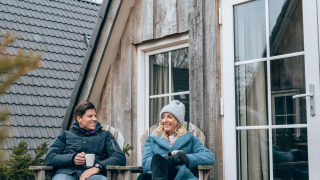 Zwei Personen entspannen sich auf der Terrasse der Wellness Lodge in Hof van Salland, Niederlande, im Winter.