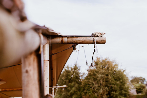 Close-up van een safaritent glamping-structuur met touwen en houten palen bij Holiday park Eigen Wijze, Nederland.
