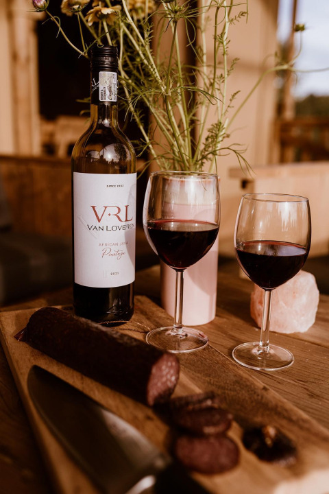 Vino y embutido sobre tabla de madera en tienda glamping en Holiday park Eigen Wijze, Países Bajos.