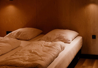 Camera da letto in una tiny house al Holiday park Eigen Wijze nei Paesi Bassi con letto e luce soffusa.
