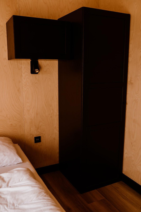 Moderne sort garderobe og skab i et kompakt soveværelse i Tiny house ved Holiday park Eigen Wijze, Holland.