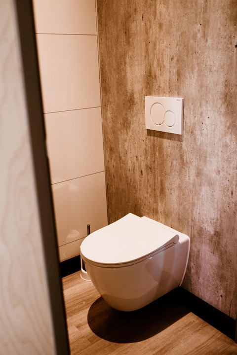 Modern hangtoilet met hout- en betonelementen in een tiny house bij Holiday park Eigen Wijze, Nederland.