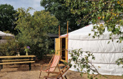 Vue extérieure d’une yourte mongole avec chaises longues et banc au Zomerlicht Nature House, Pays-Bas.