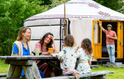 Famille réunie devant une yourte mongole au gîte nature Zomerlicht aux Pays-Bas.
