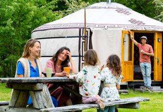 Famiglia si rilassa vicino a una yurta mongola presso la casa nella natura Zomerlicht nei Paesi Bassi.