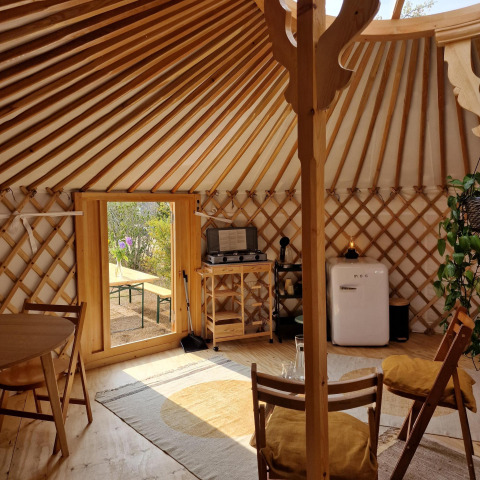 Interior de una yurta mongola en Zomerlicht, Países Bajos, con muebles y decoración de madera acogedora.