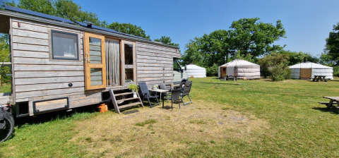 Foto esterna di una casa nella natura Mongoolse Yurt e due yurte a Zomerlicht nei Paesi Bassi in una giornata di sole.