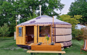 En mongolsk yurt med træindgang, bord dækket til tre, og natur omgivelser ved Zomerlicht i Holland.