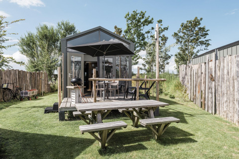 Cabaña Rescue en Duynpark Het Zwanenwater, Países Bajos, con terraza de madera y mesa de picnic al aire libre.