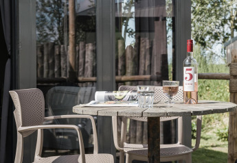 Tavolo esterno con vino e bicchieri al Rescue cottage presso Duynpark Het Zwanenwater, Paesi Bassi.