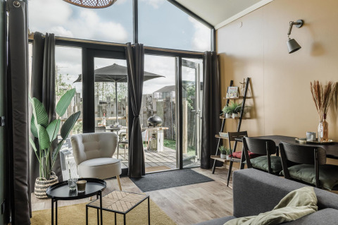 Bright living area in Rescue cottage at Duynpark Het Zwanenwater, Netherlands, with modern decor and patio view.